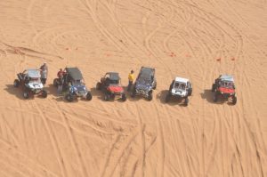 an arial view of six UTVs in the desert sand